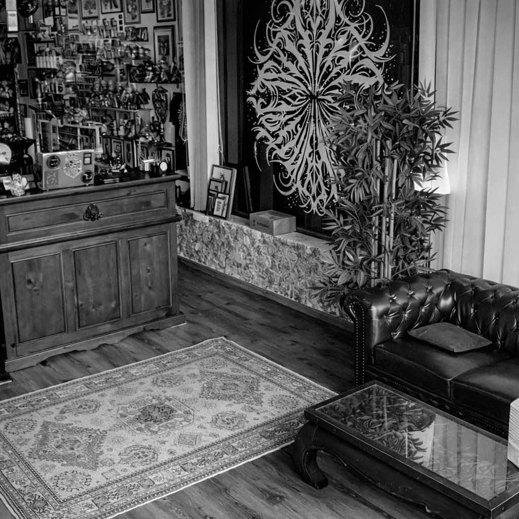 Ein schwarz weißes stilvolles Zimmer mit Ledersofa, Holzmöbeln und Pflanzen